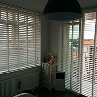 woonhoek met witte lamellen en hun ladderband