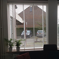 woonkamer met licht witte jaloezieen